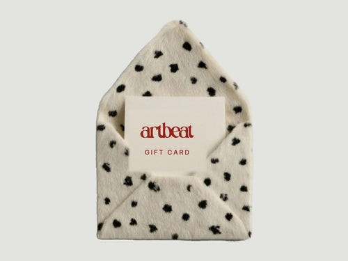 A spotted envelope holding a card that reads artbeat gift card